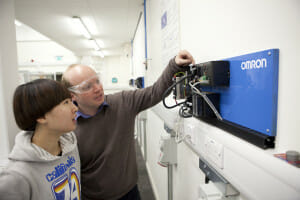 Alan-Thorne-Technical-Officer-for-the-Automation-Laboratory-and-MET-course-lecturer-demonstrates-an-Omron-PLC-to-a-student-300x200